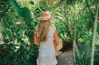 Guest walking along a tropical garden pathway at Boardwalk Boutique Hotel Aruba
