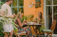 Guests enjoying a meal on a casita patio with outdoor seating and a barbecue grill at Boardwalk Boutique Hotel Aruba.