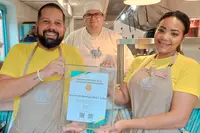 Team celebrating vegan-friendly recognition at The Coco Café in Aruba, aligned with the wellness values of Boardwalk Boutique Hotel Aruba.