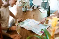 Guests planning meaningful holiday activities at Boardwalk Boutique Hotel Aruba, embracing connection and togetherness by looking at a treasure map .