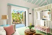 Coco Deluxe Casita living area at Boardwalk Boutique Hotel Aruba with sofa seating and indoor-outdoor terrace view.
