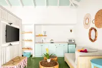 Coco Deluxe Casita kitchenette and lounge area at Boardwalk Boutique Hotel Aruba with airy tropical interior.