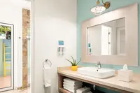 Coco Deluxe Casita bathroom at Boardwalk Boutique Hotel Aruba with sink vanity and walk-in shower.