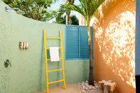 Coco Deluxe Casita outdoor shower area with privacy wall and tropical design at Boardwalk Boutique Hotel Aruba.