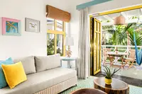 Coco Casita lounge with sofa and open doors to a private terrace at Boardwalk Boutique Hotel Aruba.