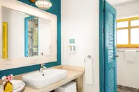 Coco Casita bathroom at Boardwalk Boutique Hotel Aruba with vanity sink, mirror, and modern shower.