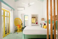 Coco Casita bedroom at Boardwalk Boutique Hotel Aruba with king bed and airy tropical interior.
