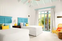 One-Bedroom Casita bedroom setup at Boardwalk Boutique Hotel Aruba with two beds and garden-view windows.