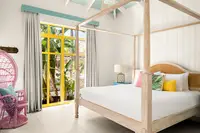 One-Bedroom Casita bedroom at Boardwalk Boutique Hotel Aruba with four-poster bed and airy tropical design.