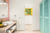 One-Bedroom Casita bathroom at Boardwalk Boutique Hotel Aruba with vanity sink and walk-in shower.