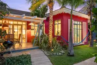 One-Bedroom Casita at Boardwalk Boutique Hotel Aruba at night with lit terrace and tropical garden path.
