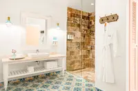 Plunge Pool Casita bathroom at Boardwalk Boutique Hotel Aruba with double vanity, patterned tile floor, and walk-in rain shower.
