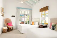 Two-Bedroom Casita bedroom at Boardwalk Boutique Hotel Aruba with king bed and airy tropical decor.