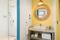 Two-Bedroom Casita bathroom at Boardwalk Boutique Hotel Aruba with walk-in shower and vanity sink.