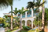 Two-Bedroom Casita exterior at Boardwalk Boutique Hotel Aruba surrounded by palm trees and tropical gardens.