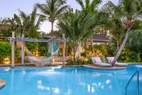 Main pool at Boardwalk Boutique Hotel Aruba surrounded by lush tropical gardens.