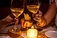 Candlelit dinner at The Coco Café at Boardwalk Boutique Hotel Aruba with wine glasses and evening ambiance.