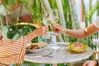 Guests toasting over lunch at The Coco Café at Boardwalk Boutique Hotel Aruba.