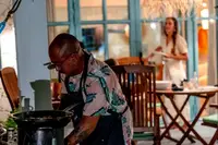 Private Dinner with Taki at an outdoor stove on a porch, warmly lit at night. 