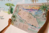 Guest holding a treasure-style island map guide at Boardwalk Boutique Hotel Aruba.