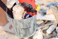Beach cleanup with gloves and bucket near Boardwalk Boutique Hotel Aruba