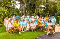 Boardwalk Boutique Hotel Aruba team group photo in a tropical garden with palm trees and greenery.