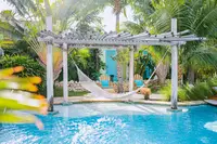 Pool area at Boardwalk Boutique Hotel Aruba with pergola and hammocks.