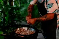 Private chef Taki grilling a BBQ dinner on a patio at Boardwalk Boutique Hotel Aruba.