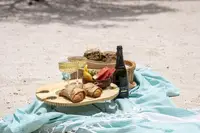 Beach picnic to go setup with snacks and drinks on a blanket in Aruba.