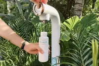 Guest refilling a reusable water bottle at Boardwalk Boutique Hotel Aruba