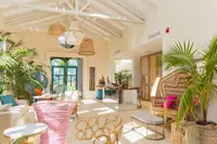 ight, tropical-style lobby at Boardwalk Boutique Hotel Aruba with plants, seating area, and airy high ceiling.