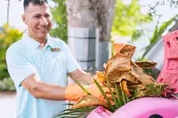 Team member of Boardwalk Boutique Hotel Aruba participating in a sustainability initiative as part of the Green Globe Certification commitment.