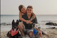 Family and rescue dogs on Palm Beach in Aruba near Boardwalk Boutique Hotel Aruba, reflecting compassion and island life.