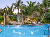 Main pool at Boardwalk Boutique Hotel Aruba surrounded by lush tropical gardens.
