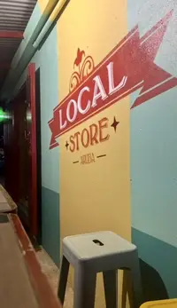 Colorful “Local Store” wall sign in Aruba, photographed inside the shop entrance.