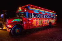 Kukoo Kunuku party bus in Aruba at night, brightly lit for an island nightlife tour.