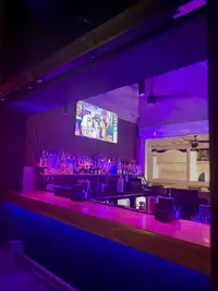 Inside Gusto Nightclub in Aruba, showing the bar area with neon lighting and a lively atmosphere.