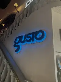 Gusto Nightclub in Aruba at night, featuring the illuminated exterior sign.