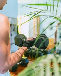 Guest lifting dumbbells in the gym/fitness room at Boardwalk Boutique Hotel Aruba