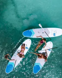Aerial view of people paddleboarding on turquoise water in Aruba.