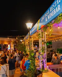 Crowds at the Authentico Aruba Culinary Festival at night with food stalls and lights in Oranjestad, Aruba.