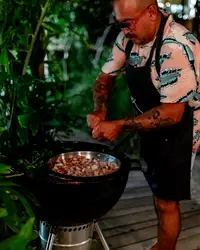 Private chef Taki grilling a BBQ dinner on a patio at Boardwalk Boutique Hotel Aruba.