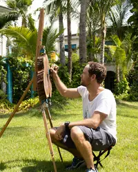 Artist Armando Goedgedrag painting on an easel during a live session in the tropical garden at Boardwalk Boutique Hotel Aruba.