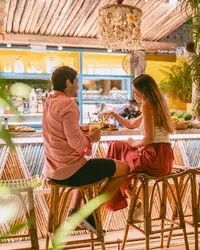 Guests toasting during outdoor dining at The Coco Café at Boardwalk Boutique Hotel Aruba.